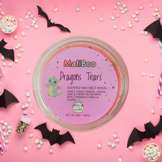 MaliBoo Dragons Tears scented wax melt wheel on a pink background with Halloween decorations.