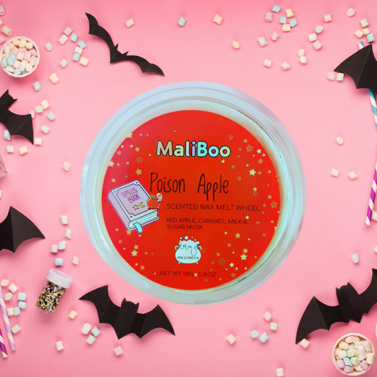 Maliboo Poison Apple scented wax melt wheel on a pink background with Halloween decorations
